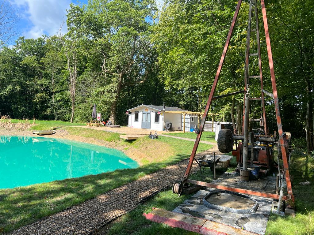 borehole drilling rig next to  lake, drilling a water well